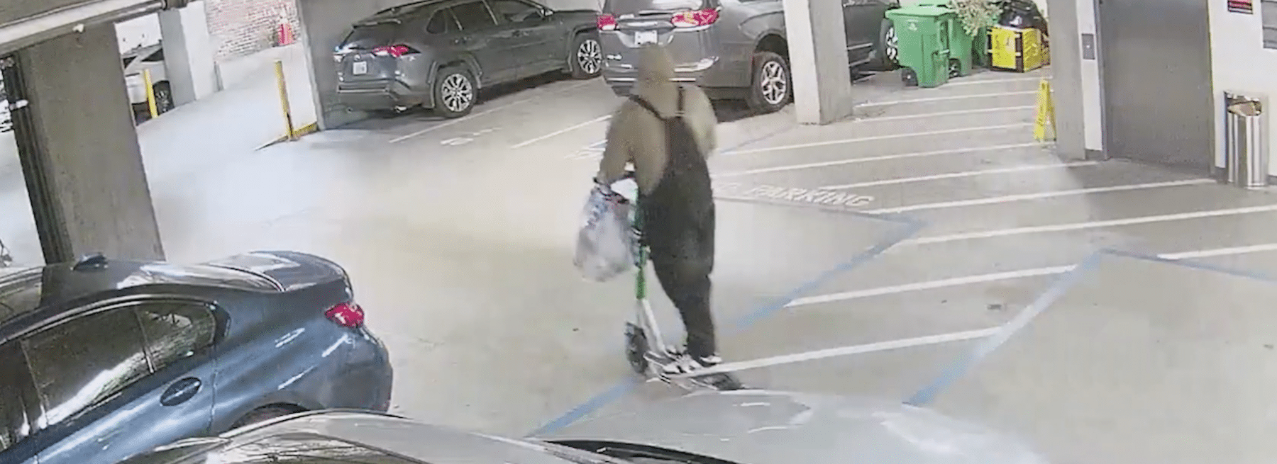 Person on scooter in apartment parking garage