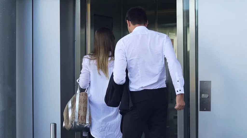 a man piggybacking into a building behind a woman