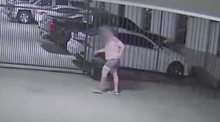 Shirtless Trespasser Climbing Parking Garage Gate Hero