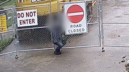 Trespasser Slips Through a Gap in Construction Site Perimeter Fencing Hero