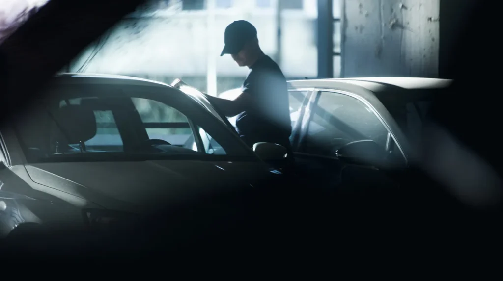 un homme debout à côté d'une voiture