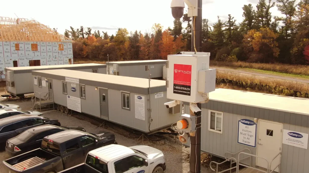 A pole with Stealth Monitoring box and cameras at a construction site